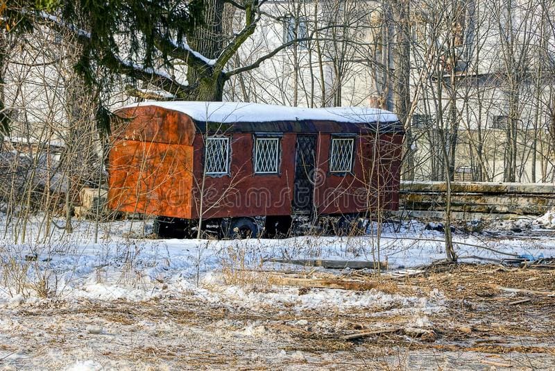 old-brown-residential-car-wheels-winter-garden-rusty-trailer-windows-snow-overgrown-park-103159363